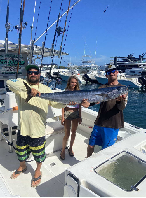 Three people holding a large fish