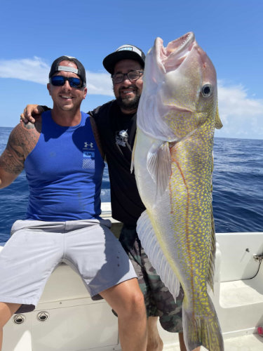 two men holding a large fish