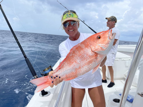 women holding a large fish