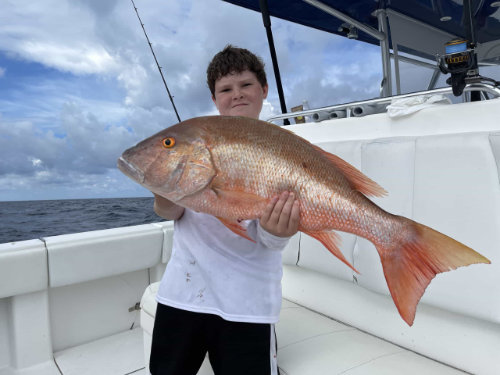 young boy holding a fish