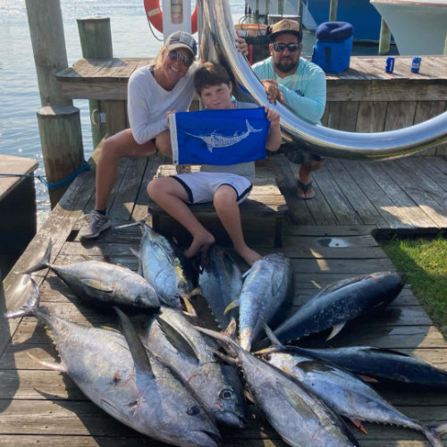 family sitting with large fishes